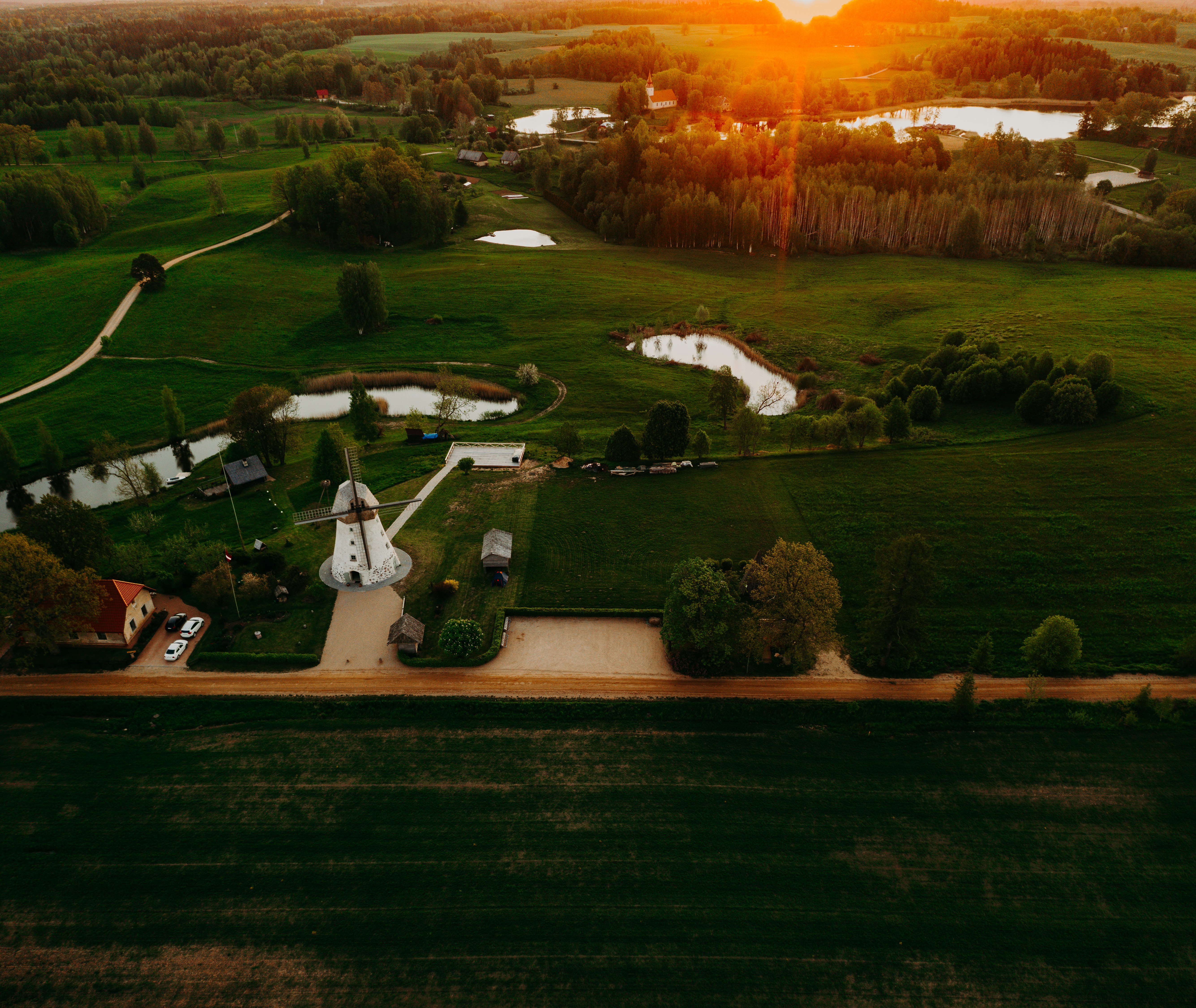 white and brown house on green grass field during sunset